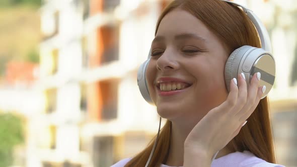 Happy Teenager in White Headphones Listening to Music Enjoying Melody Sound