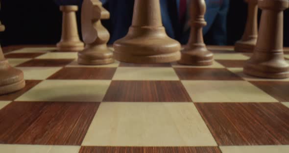 Male Hand Making Move on Chessboard with White Queen Close Up