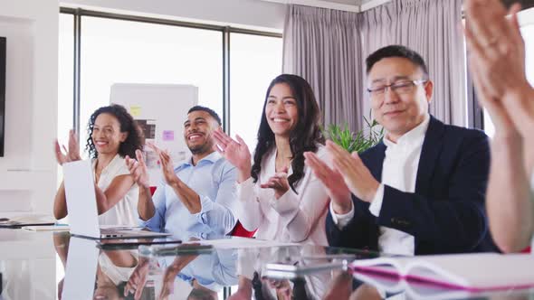 Professional businesspeople clapping together in meeting room in modern office in slow motion