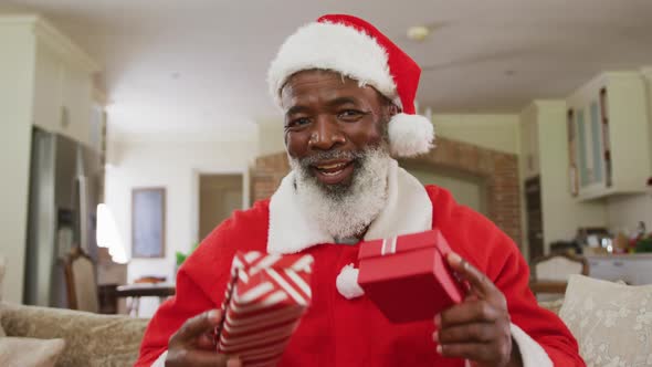 Portrait of happy senior african american man at christmas time wearing santa costume