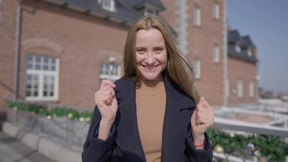 Portrait of Excited Caucasian Successful Woman Dancing with Key From Oldfashioned Luxurious Building