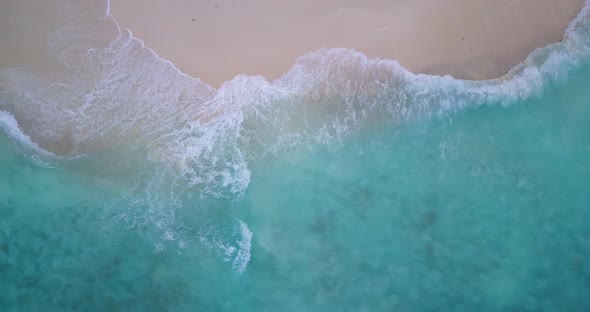 Wide angle aerial island view of a sunshine white sandy paradise beach and aqua blue ocean backgroun