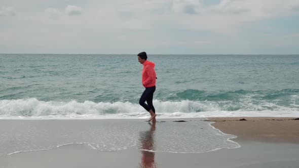 Lonely female is walking on sandy beach