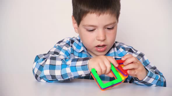 A Boy Plays with a Magnetic Constructor Gets Angry Knocks His Hands and Details on the Table