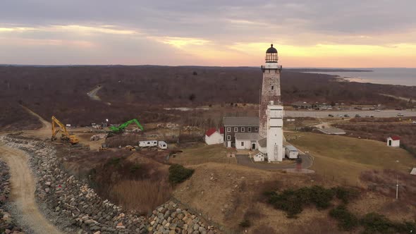 An aerial view of the Montauk lighthouse at sunset. The drone camera truck left and pan right around