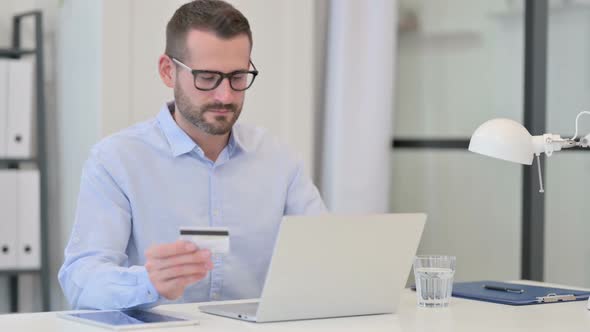 Middle Aged Man Excited By Online Shopping Success on Laptop