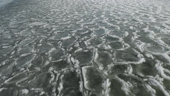 Waves rippling ice sheets over water AERIAL