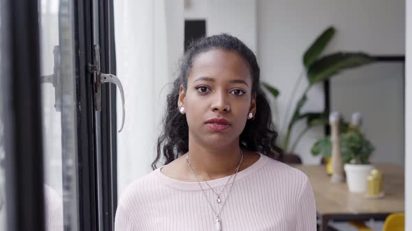 Confident Beautiful African Woman Professional with Serious Face Standing at Home in Office Looking