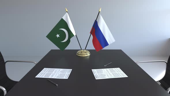 Flags of Pakistan and Russia and Papers on the Table