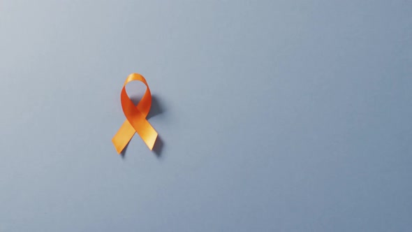 Video of orange kidney cancer or leukemia ribbon on pale blue background