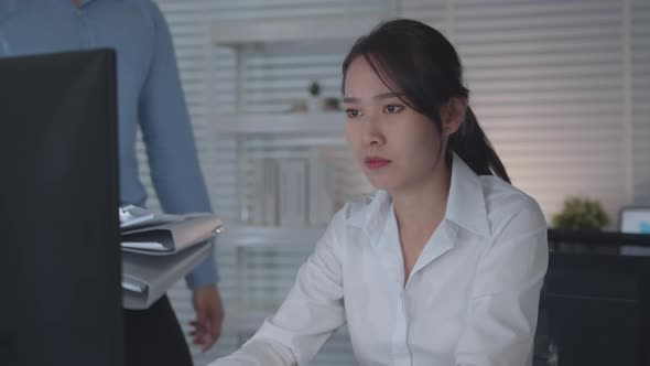 Tired and Concentrated Businesswoman sitting at desk using desktop computer working