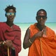 Young Masai Tribe Members in Red Dresses and Sunglasses Standing on Sand Beach of the Indian Ocean - VideoHive Item for Sale