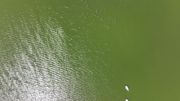 An aerial view over a lake in Flushing Meadow Corona Park in Queens, NY on a sunny day. The camera t