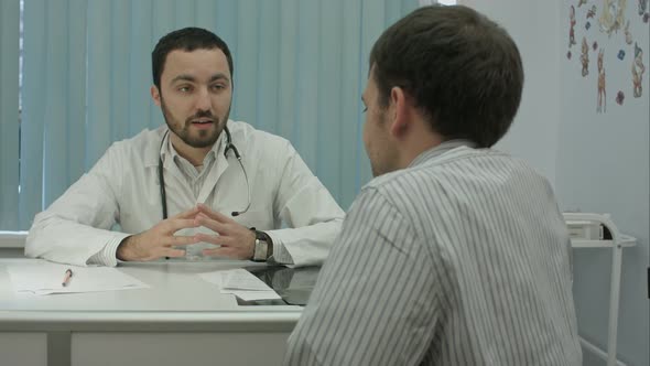 Male Bearded Doctor in Clinic with Male Patient Shake Hands