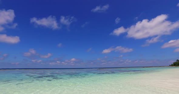 Tropical flying island view of a white paradise beach and blue sea background in vibrant 4K