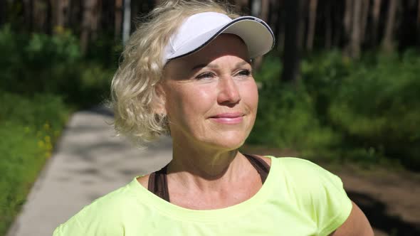 Mature Woman in White Cap Looks at Sun Smiling Closeup