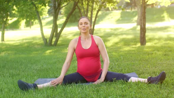 Pregnant Woman Stretching on Nature