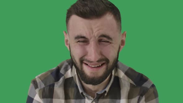 Close-up of Crying Adult Man. Portrait of Upset Caucasian Handsome Guy at Green Screen Background