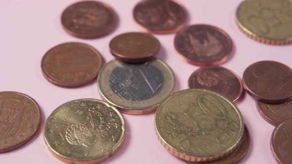 Euro coins and cents on a pink background.