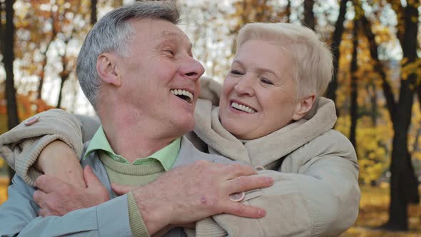 Adult Old Woman Hug Beloved Husband By Shoulders Elderly Married Couple Hugging in Autumn Park