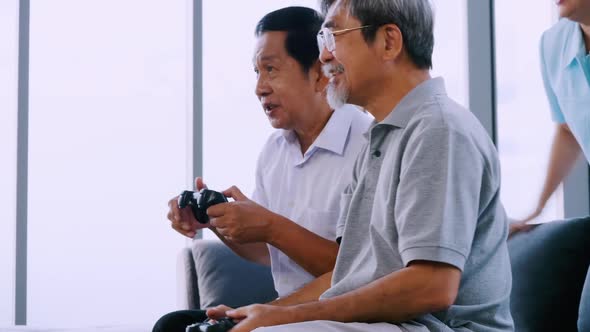 Group of senior friends playing video game together in a retirement home