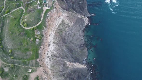 Aerial view of the coast with a blue sky and a blue sea, from a helicopter