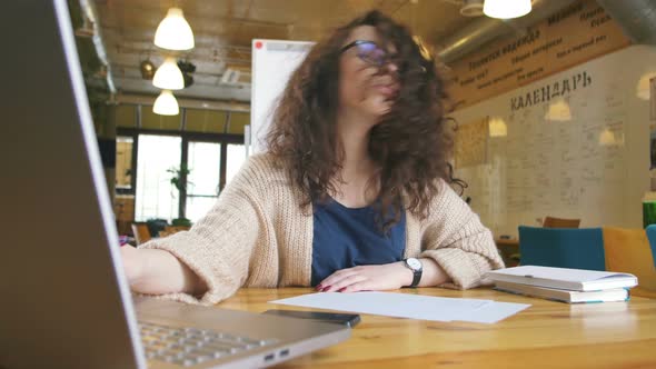 Young Happy Woman Working in the Office Writing Something and Using Computer