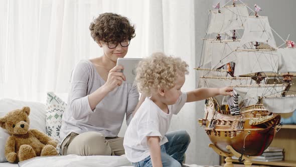 Mother Capturing Moment on Tablet alt