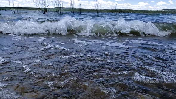 Waves with splashing water and blue skies and white clouds at Possum Kingdom Lake