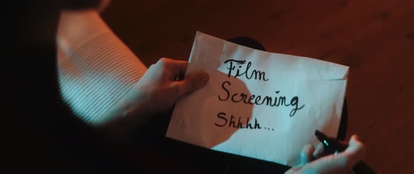 Hands of young woman writing note on a piece of paper