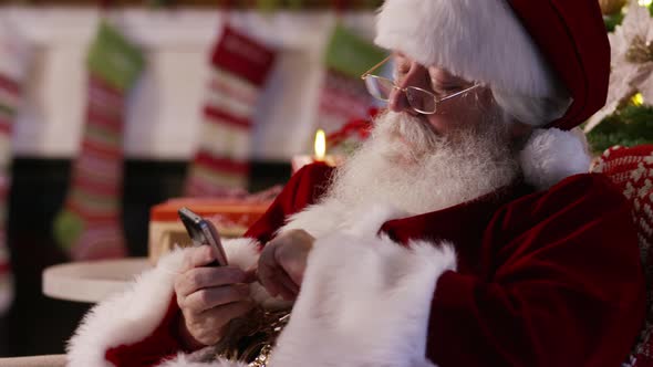 Santa Claus using cell phone, closeup alt