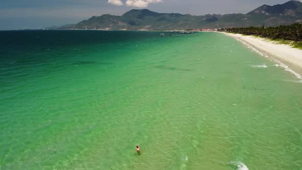 Aerial View Over Beautiful Beach with Crsytal Clear Pristine Water on Summer Day.