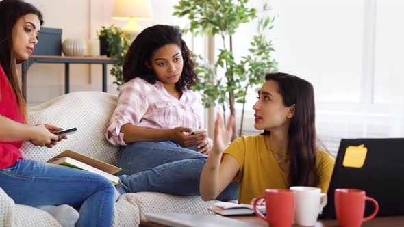 Female student receiving bad news on laptop and friends cheering her up