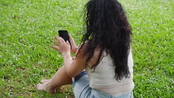 European Woman Makes Use of a Tablet or Phone with a Smartphone, Leafs or Prints with Her Finger