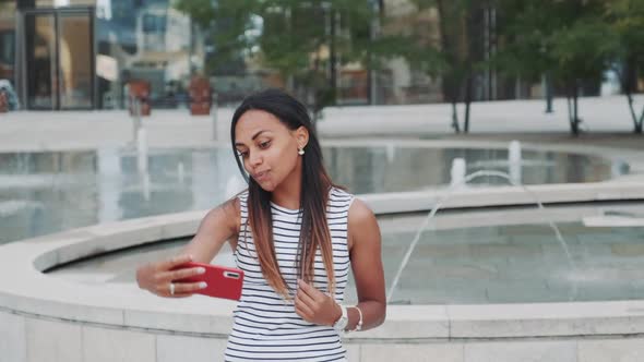 Attractive Black Lady Taking Selfie in Front of Fountains
