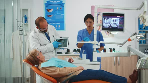 Dentist Showing on Tablet Teeth X-ray