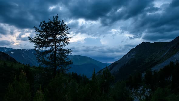 Clouds Fly by Mountain Valley at Sunset