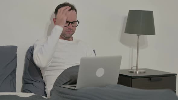 Casual Man Reacting to Loss on Laptop in Bed