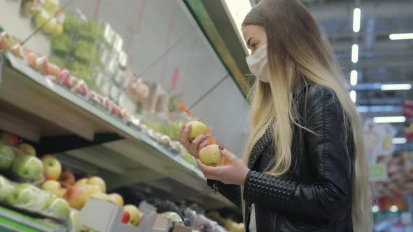 Woman with Face Mask is Buying Apples in Supermarket Epidemic