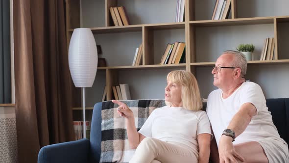 A European Elderly Couple is Relaxing at Home on the Sofa They are Talking to Each Other