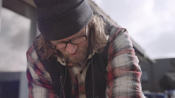 Bearded Carpenter In Glasses Working Outdoors