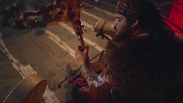 Yakut Man in National Costume Plays String Instrument