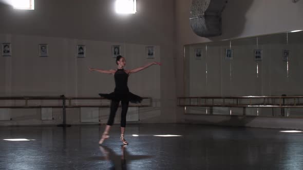 Professional Woman Ballerina in Black Tutu Dancing in an Empty Mirror Studio