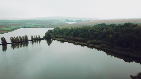 view of the beautiful countryside with lakes, trees and a wooden arbor