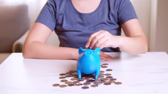 Saving money concept, Asian woman hand putting money coin into piggy bank.