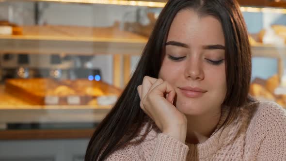 Lovely Young Woman Smiling To the Camera, Drinking Coffee in the Morning