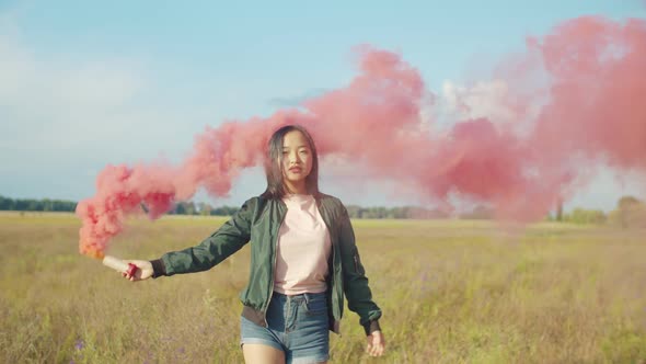 Asian Pretty Woman with Red Smoke Bomb in Nature