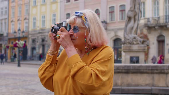 Senior Woman Tourist Taking Pictures with Photo Camera in Summer City Center Life After Retirement