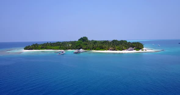 Tropical fly over island view of a white sand paradise beach and aqua blue ocean background 