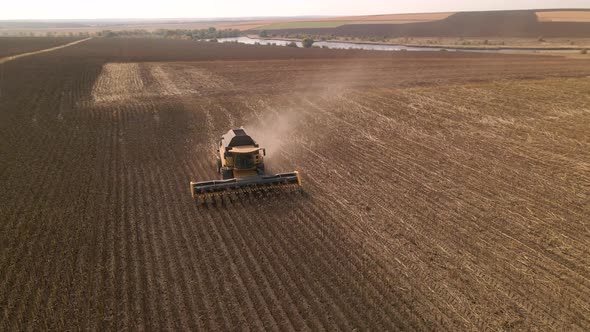 Slow Motion Aerial View of Combine Harvester Working on a Field